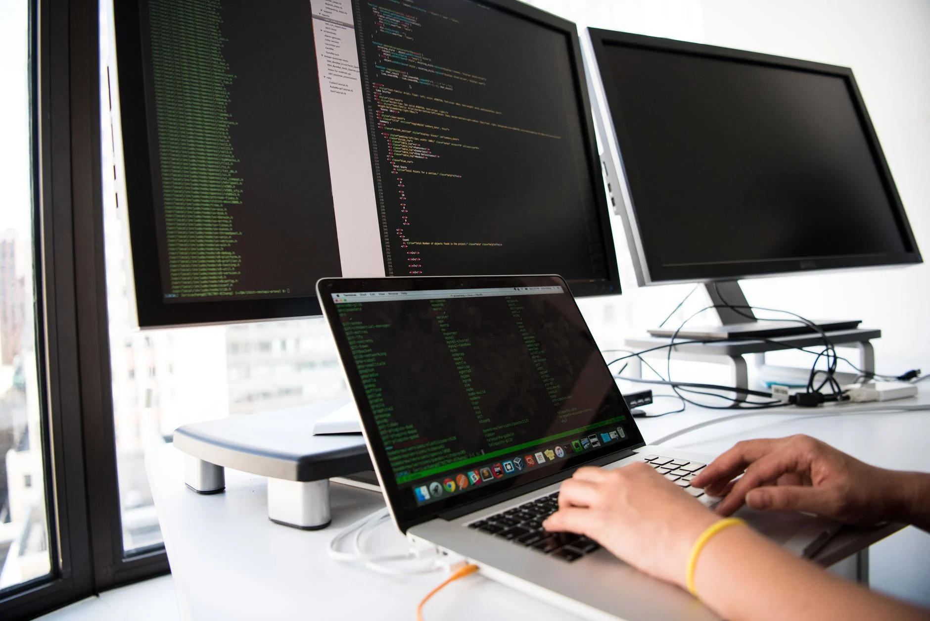 Developer working across multiple screens with lines of code and Docker and OVH logos