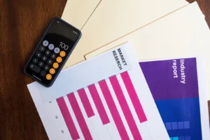 Smartphone et documents d'analyse de marché sur une table en bois.