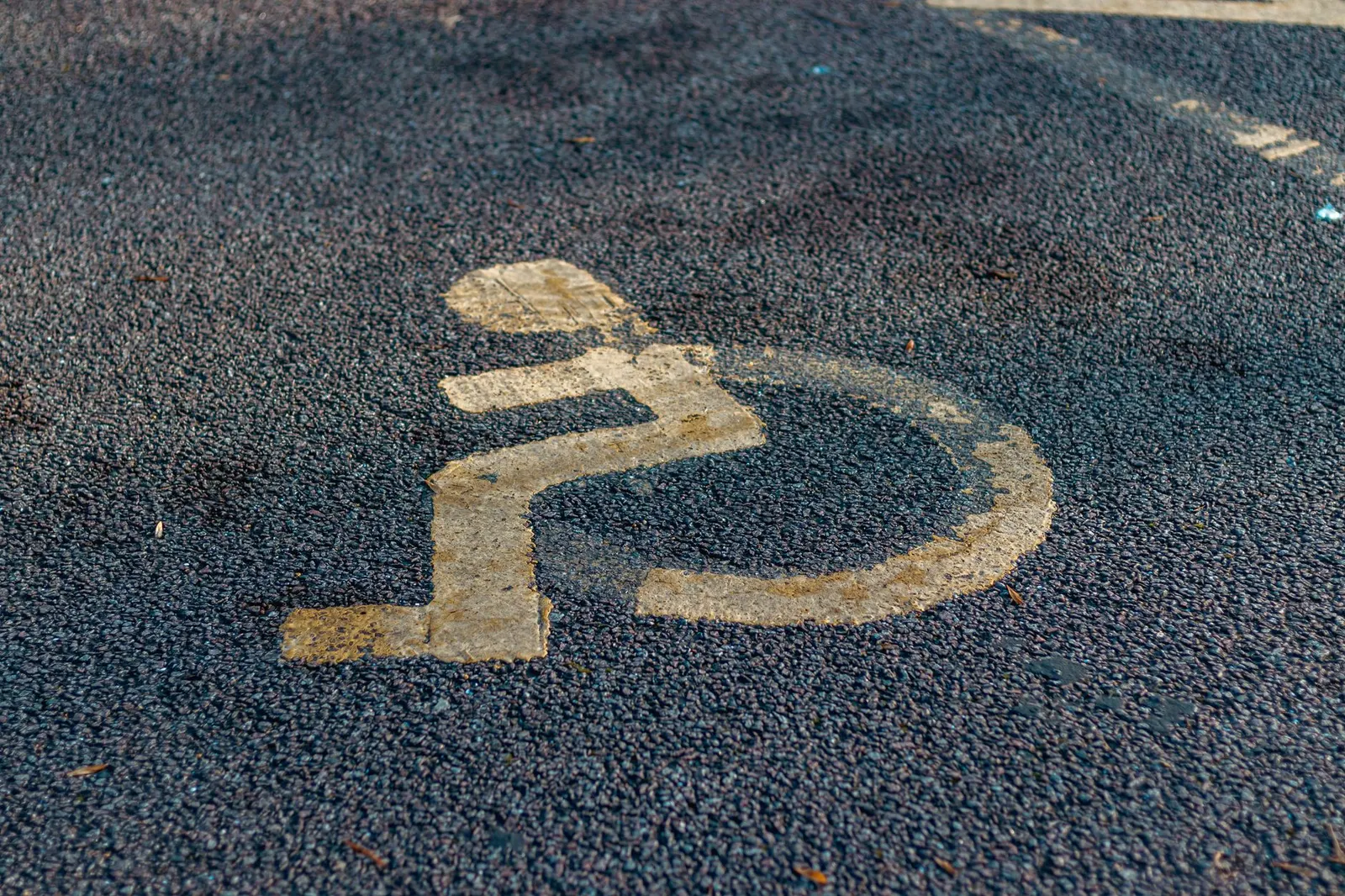 Main tenant une tablette affichant un site web avec un logo d'accessibilité, symbolisant la maintenance continue.