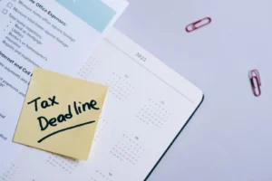 Un post-it jaune sur un calendrier met en évidence une date limite fiscale.