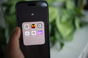 Main tenant un smartphone affichant des applications d'IA.
