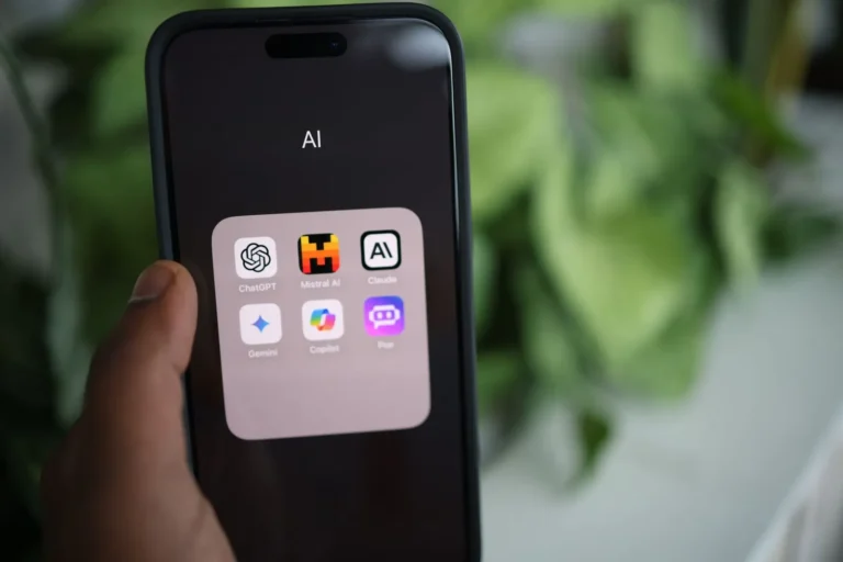 Main tenant un smartphone affichant des applications d'IA.